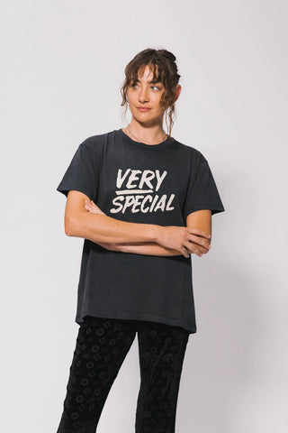 Person wearing a black t-shirt with 'VERY SPECIAL' text on a plain background